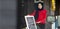 Muslim lady standing outside the halal restaurant with open sign to welcome and greeting the customer