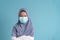 Muslim little girl wearing a protection mask epidemic of flu or COVID-19 on blue background isolated