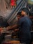 Muslim male vendor cooking selling halal foods and Kababs from roadside stall at night market in holy month of Ramadan . Vertical