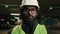 Muslim man Arabian worker Indian builder ethnic engineer serious looking at camera wearing hard hat helmet manufacture