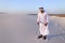 Muslim man develops sand along wind standing in middle of desert