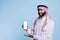 Muslim man presenting smartphone screen