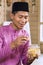 Muslim man taking traditional Malay cookie