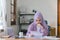 The Muslim millennial woman wearing a purple hijab appears stressed while working on her laptop from home, looking