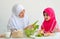 Muslim mother show vegetable and while little girl with pink hijab look at the vegetable