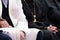 A Muslim mullah in white clothes and a Christian priest in a black cassock are sitting next to each other. The concept of