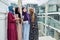 Muslim multiethnic group of girls looks at smart phone in hand of african woman