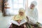 Muslim parent and daughter reading quran