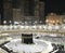 Muslim pilgrims in prostration sujud position facing the Kaabah during evening prayer.