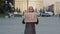Muslim sad upset worried woman wearing hijab islamic frightened poor girl standing in city on street holding cardboard
