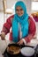 Muslim traditional young girl making food in kitchen