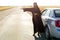 Muslim woman asks for help on the road while standing near her car