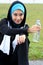 A muslim woman athlete holding a bottle of mineral