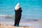 Muslim woman in black robe and white head scarf looking at her c