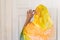 Muslim woman in a colorful scarf looking on peephole door