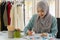 Muslim woman dressmaker in hijab working in fashion design shop