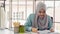 Muslim woman dressmaker in hijab working in fashion design shop