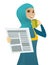 Muslim woman drinking coffee and reading newspaper