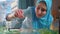 Muslim woman feeds fish in an aquarium at home close up