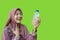 muslim woman feeling refreshed after drinking water with green background