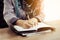 Muslim woman hand with writing some note onto anotebook by pen in the morning