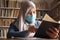 Muslim woman learning studying reading book in library during covid19 pandemic, wearing protective medical face mask