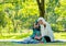 Muslim woman point to camera and girl show thumps up action during reading some books in the garden