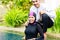 Muslim woman in pool greeting her husband