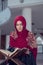 Muslim Woman Reading Koran Or Quran Wearing Traditional Dress At The Mosque