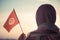 Muslim woman in scarf with Tunisia flag of at sunset.