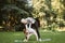 Muslim woman in sportswear teaching her preschool cute daughter how to do side tilts in the park