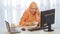 Muslim woman in traditional dress in the office speaks on the phone and works on the computer.