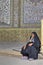 Muslim woman, wearing in Islamic clothing, sits inner courtyard