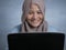 Muslim Woman Working on Laptop and Smiling