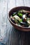 Mussels in clay pot over dark wood background