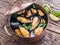 Mussels in copper pan on the wooden table.