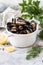 Mussels with fresh herbs and lemon in a white pan on a concrete background. Gourmet seafood. Copy space