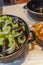 Mussels in a saucepan and fries on a table in a cafe. Traditional Belgian snack. Close-up. Vertical