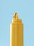 Mustard plastic bottle isolated on a blue background