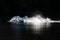 A mute swan landing in a lake with full speed.