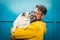 My best friend dog concept with funny scene adult man with beard and pug dog kissing him on the face - people and animals have fun