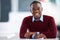 My career is trending. Portrait of a smiling young businessman sitting at a desk in an office.