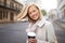 My commute is always easier with coffee. Head and shoulders portrait of a young woman walking in the street with a cup