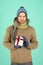 My congratulations. Man bearded handsome wear winter hat scarf gloves hold gift box. Hipster hold christmas gift with