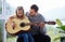 My dads my personal superhero. a young father teaching his daughter to play the guitar at home.