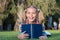 My education came from encyclopedia. Happy little girl read encyclopedia on green grass. Adorable small child smile with