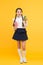 This is my favorite taste. Healthy nutrition. Schoolgirl holding juice bottle on yellow background. Quenching thirst