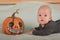 My first Halloween. Small child and pumpkin. Autumn concept, halloween, bats, pumpkins, newborn close-up and copy space