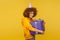 My precious. Portrait of happy pleased curly-haired woman embracing huge gift box and smiling to camera