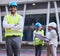 My team will find a solution. a handsome young architect standing with his arms folded while his colleagues discuss